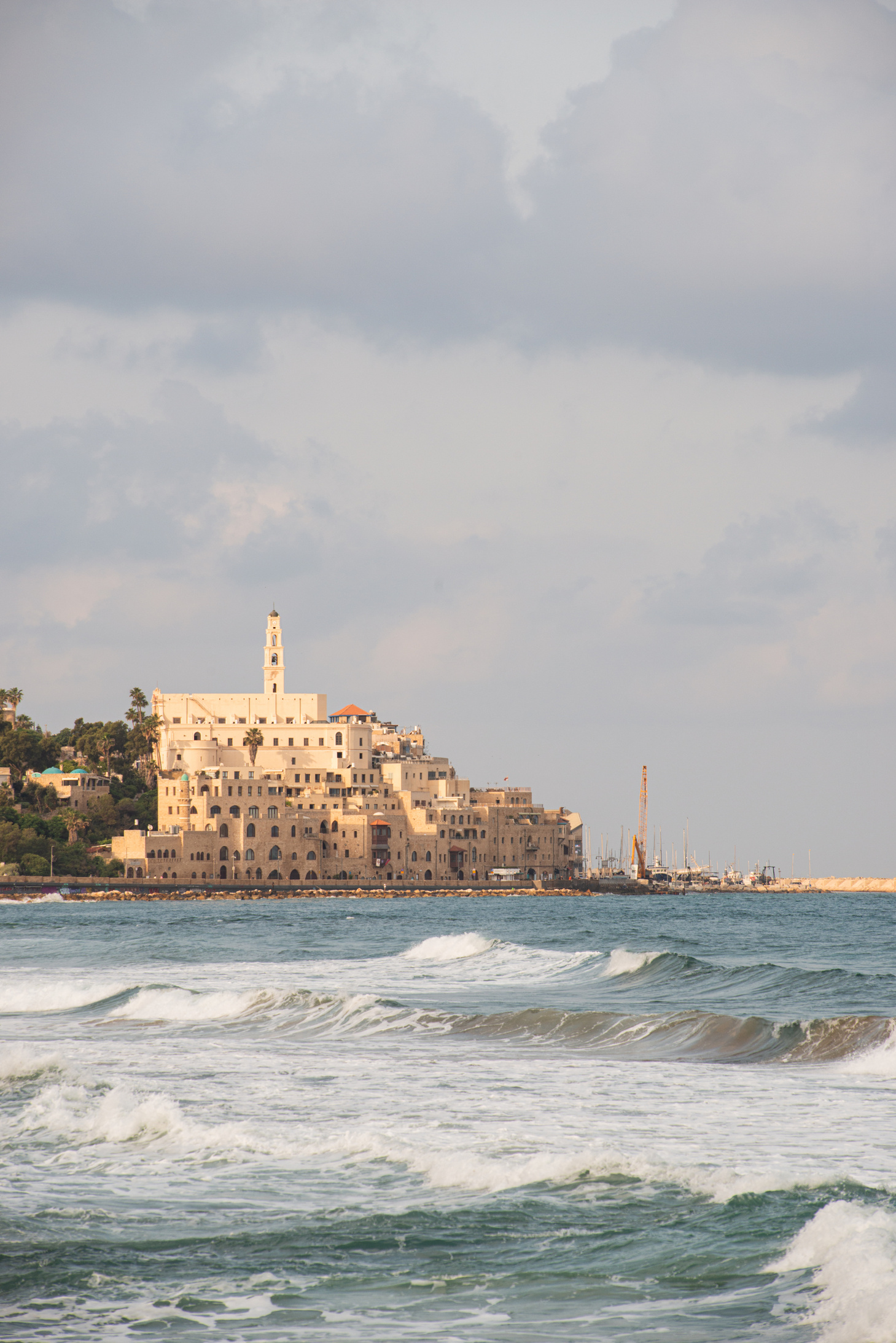 Ancient Jaffa Old City rising from Mediterranean Sea waves at golden hour morning light Tel Aviv Israel